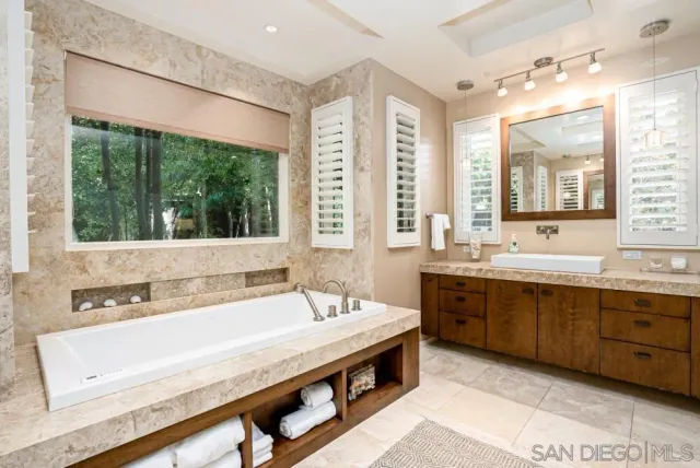 a spacious bathroom with a large tub and sink