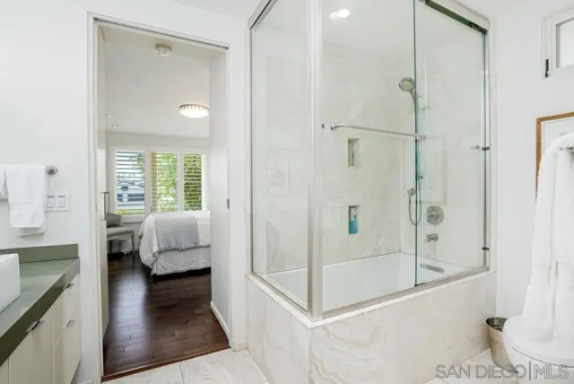 a en suite spacious bathroom with a glass door shower and bedroom