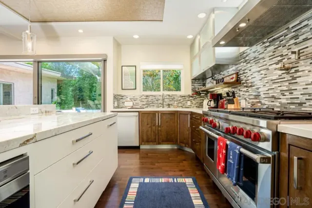 a kitchen with stainless steel appliances granite countertop a stove and a sink