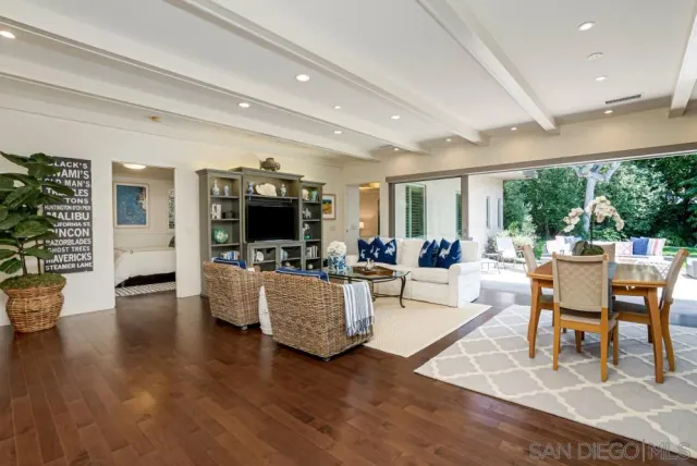 a living room with furniture a flat screen tv and a large window