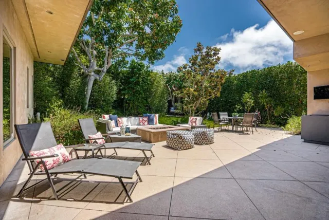 a view of a patio with dining table and chairs and potted plants