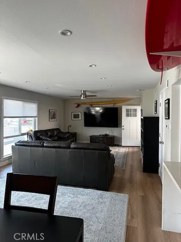 a living room with furniture a flat screen tv and kitchen view