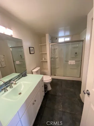 a spacious bathroom with a double vanity sink toilet mirror and shower