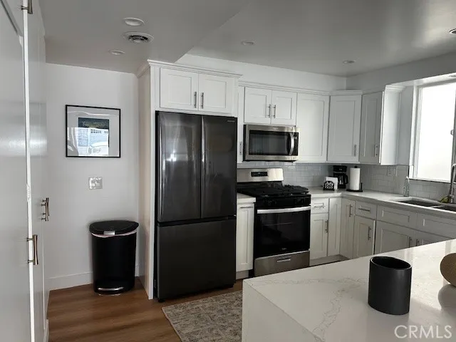 a kitchen with stainless steel appliances granite countertop a refrigerator and a stove top oven