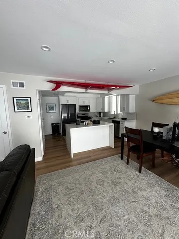 a living room with furniture a kitchen view and a piano