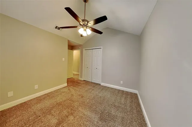 an empty room with a ceiling fan and a window