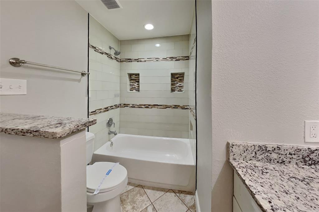 1009 Schrade Trail Mesquite, TX 75181 - Photo 16 of 19 Full bathroom with light tile patterned floors, shower combination, a textured wall, and vanity
