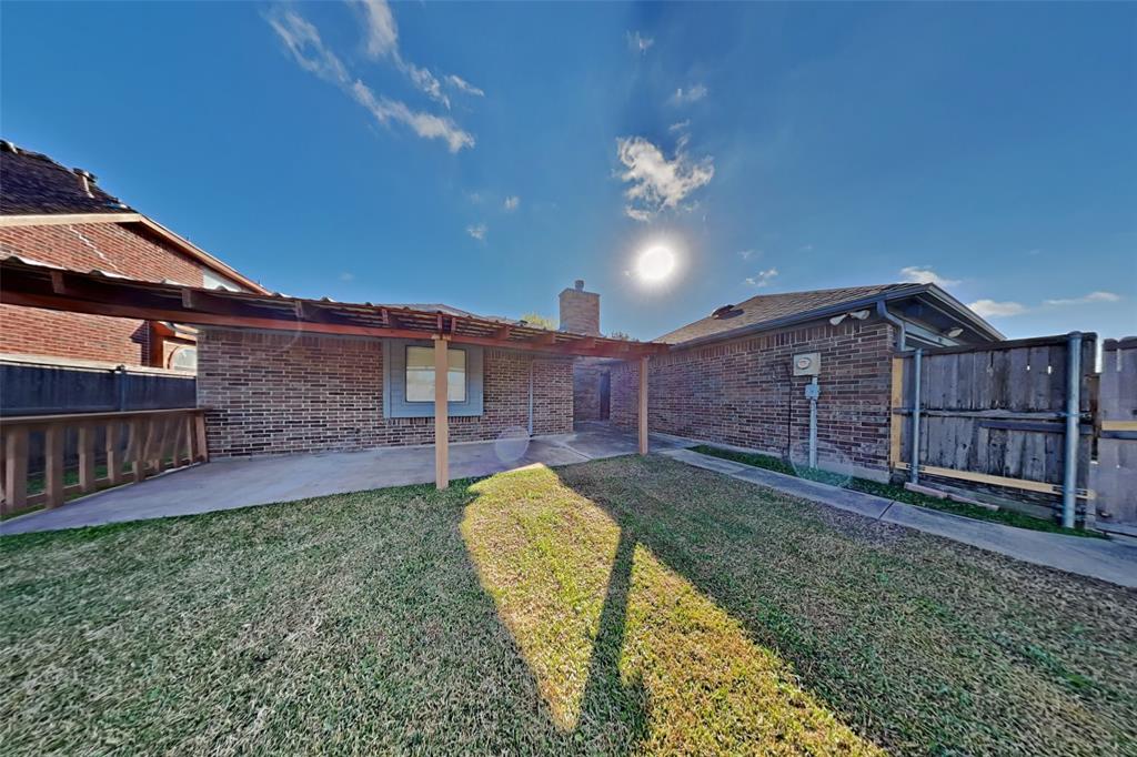 1009 Schrade Trail Mesquite, TX 75181 - Photo 18 of 19 Back of property featuring brick siding, a patio area, a chimney, and a fenced backyard