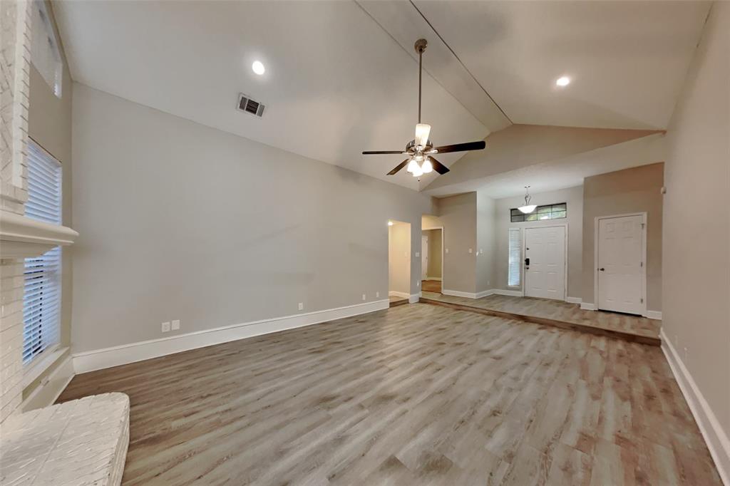 1009 Schrade Trail Mesquite, TX 75181 - Photo 3 of 19 Unfurnished living room featuring light wood finished floors, lofted ceiling, and a ceiling fan