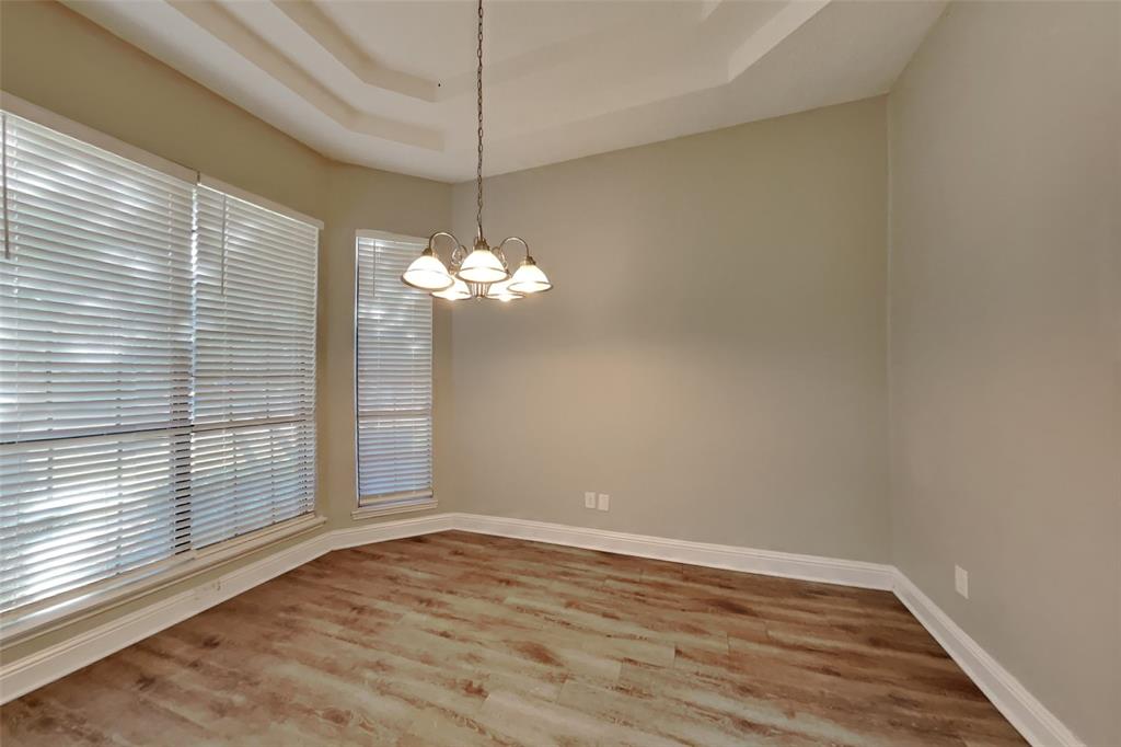 1009 Schrade Trail Mesquite, TX 75181 - Photo 5 of 19 Unfurnished room featuring wood finished floors, a tray ceiling, and a chandelier