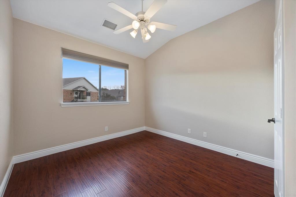 1908 Signal Ridge Place Rockwall, TX 75032 - Photo 8 of 28 a view of an empty room with wooden floor and a ceiling fan