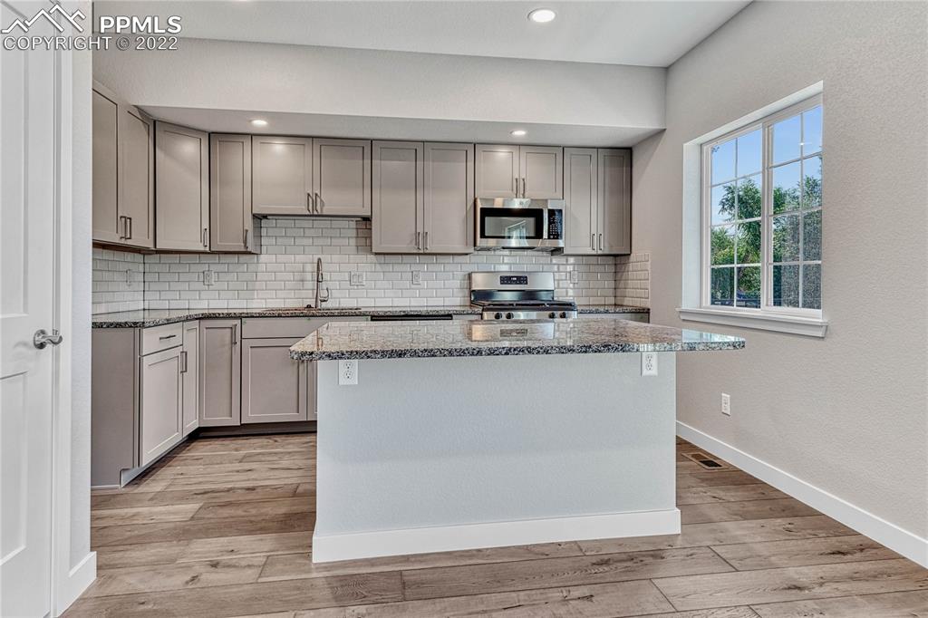 840 Promontory Rock Grove Colorado Springs, CO 80905 - Photo 3 of 11 a kitchen with stainless steel appliances granite countertop a stove a sink dishwasher and a microwave oven on the granite countertops
