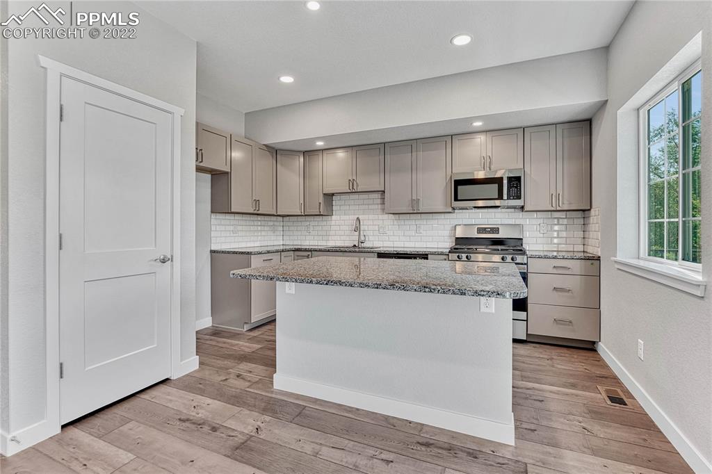 840 Promontory Rock Grove Colorado Springs, CO 80905 - Photo 4 of 11 a kitchen with kitchen island granite countertop a sink cabinets and stainless steel appliances