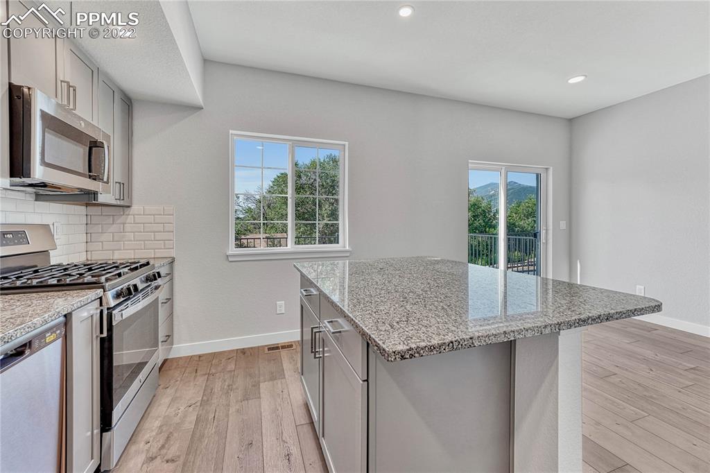 840 Promontory Rock Grove Colorado Springs, CO 80905 - Photo 6 of 11 a kitchen with granite countertop a sink stove and refrigerator