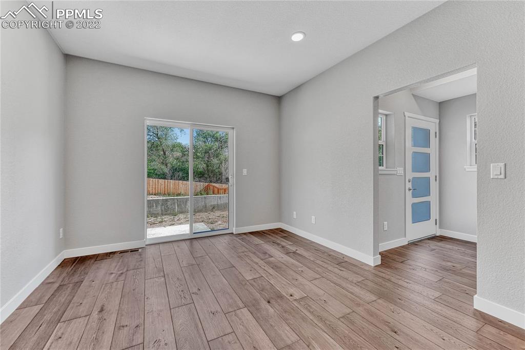 840 Promontory Rock Grove Colorado Springs, CO 80905 - Photo 8 of 11 an empty room with wooden floor and windows