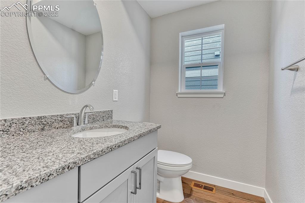 840 Promontory Rock Grove Colorado Springs, CO 80905 - Photo 10 of 11 a bathroom with a granite countertop toilet sink mirror and vanity