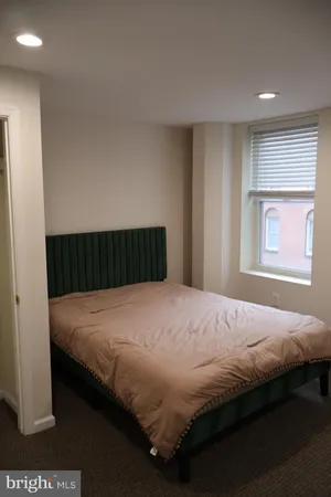 a bed sitting in a bedroom next to a window