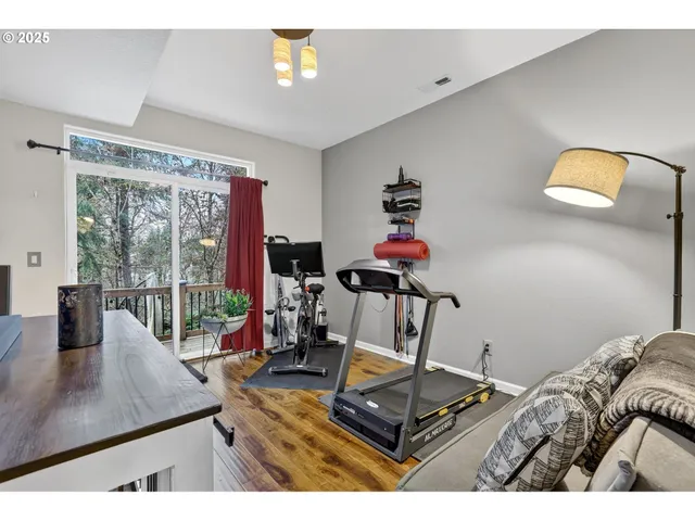 a living room with furniture a rug and gym equipment