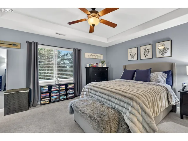 a bedroom with a bed a dresser and a flat screen tv