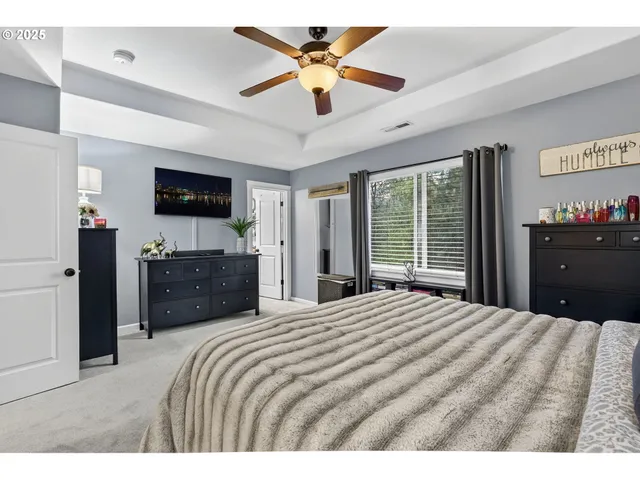 a large bedroom with a bed and a flat screen tv