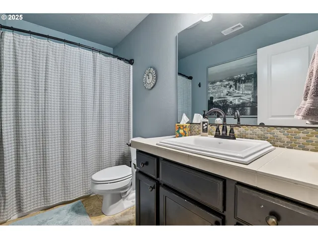 a bathroom with a sink a toilet and a mirror