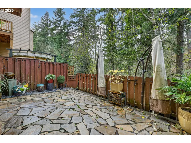 a backyard of a house with lawn chairs and wooden fence