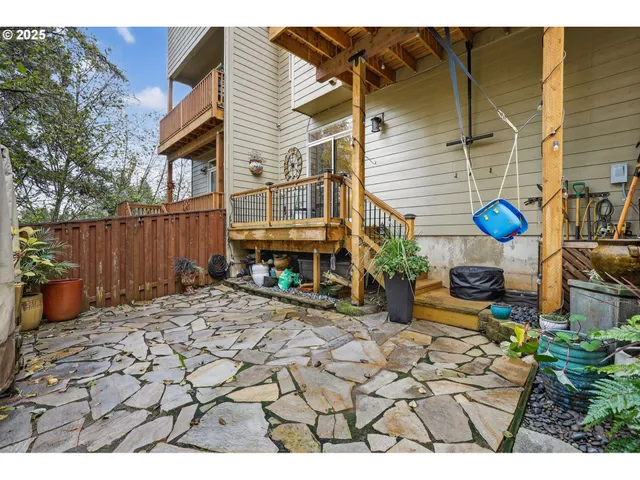 a patio with tables and chairs under an umbrella