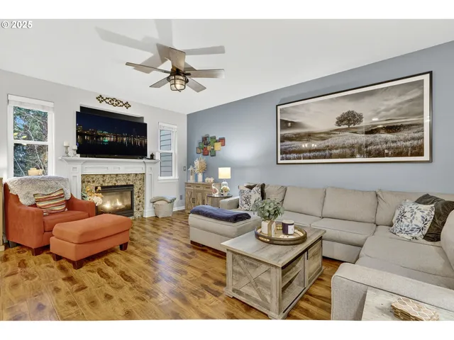 a living room with furniture and a dining table with wooden floor
