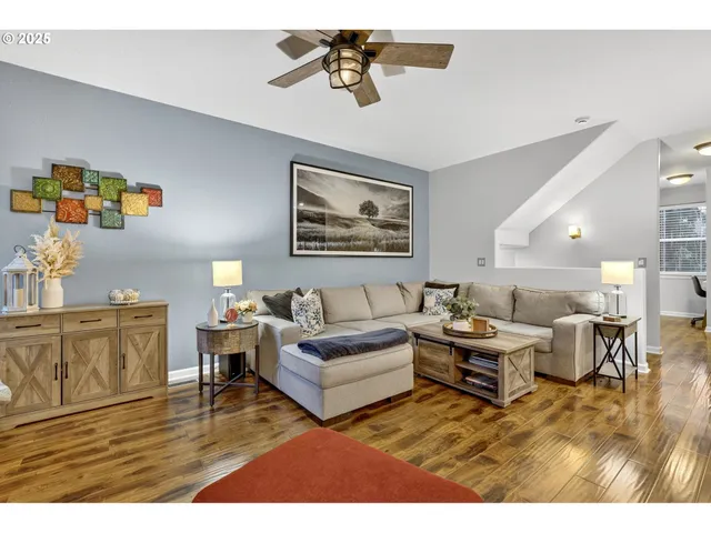 a living room with furniture kitchen view and a chandelier