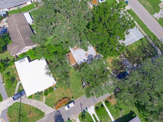 an aerial view of a house with a yard and trees
