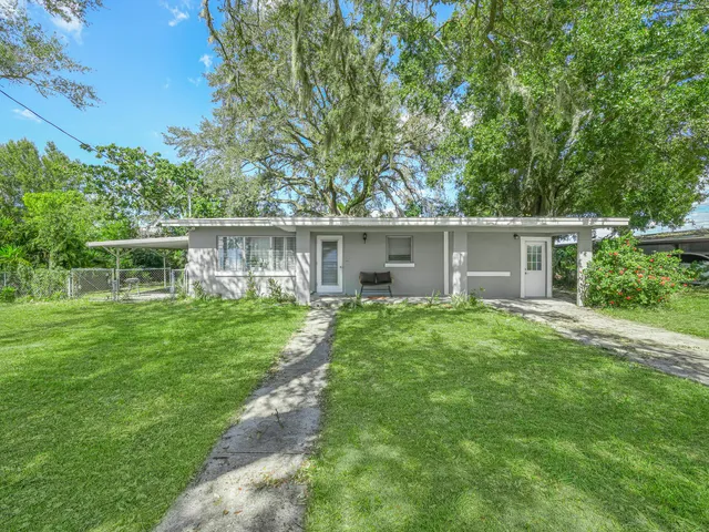 a view of house with backyard space and balcony