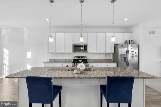 a kitchen with granite countertop a sink a center island and cabinets