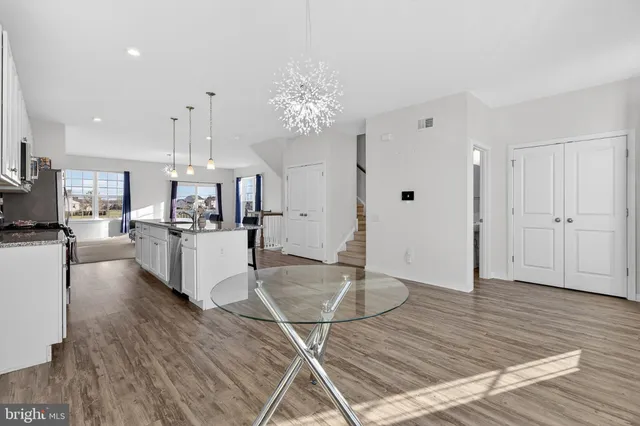 a kitchen with microwave a stove and white cabinets with wooden floor