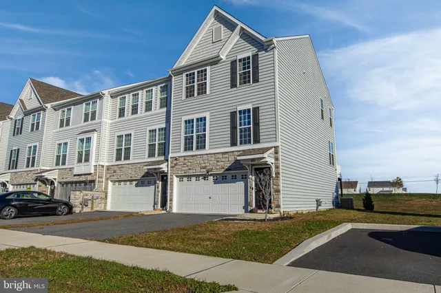 a view of a white building among the street with houses