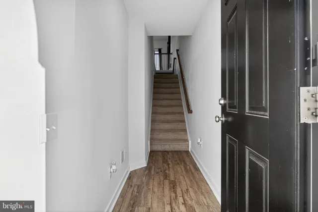 a view of a hallway with wooden floor and staircase