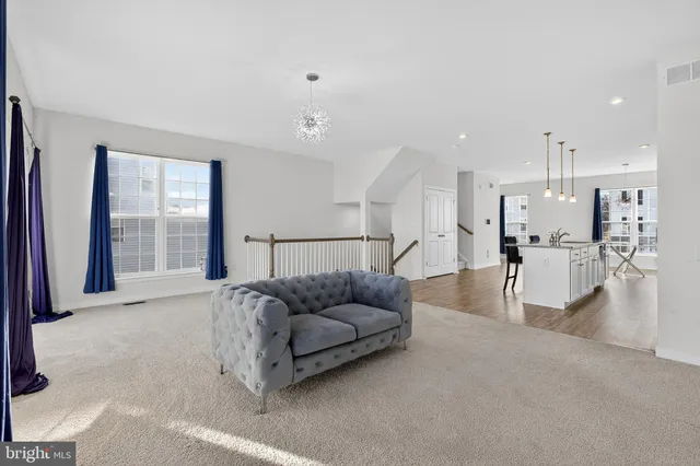 a living room with furniture and kitchen view
