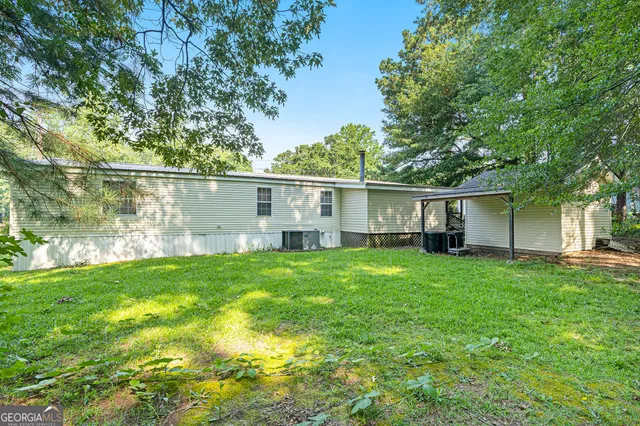 a view of a backyard with plants and large trees