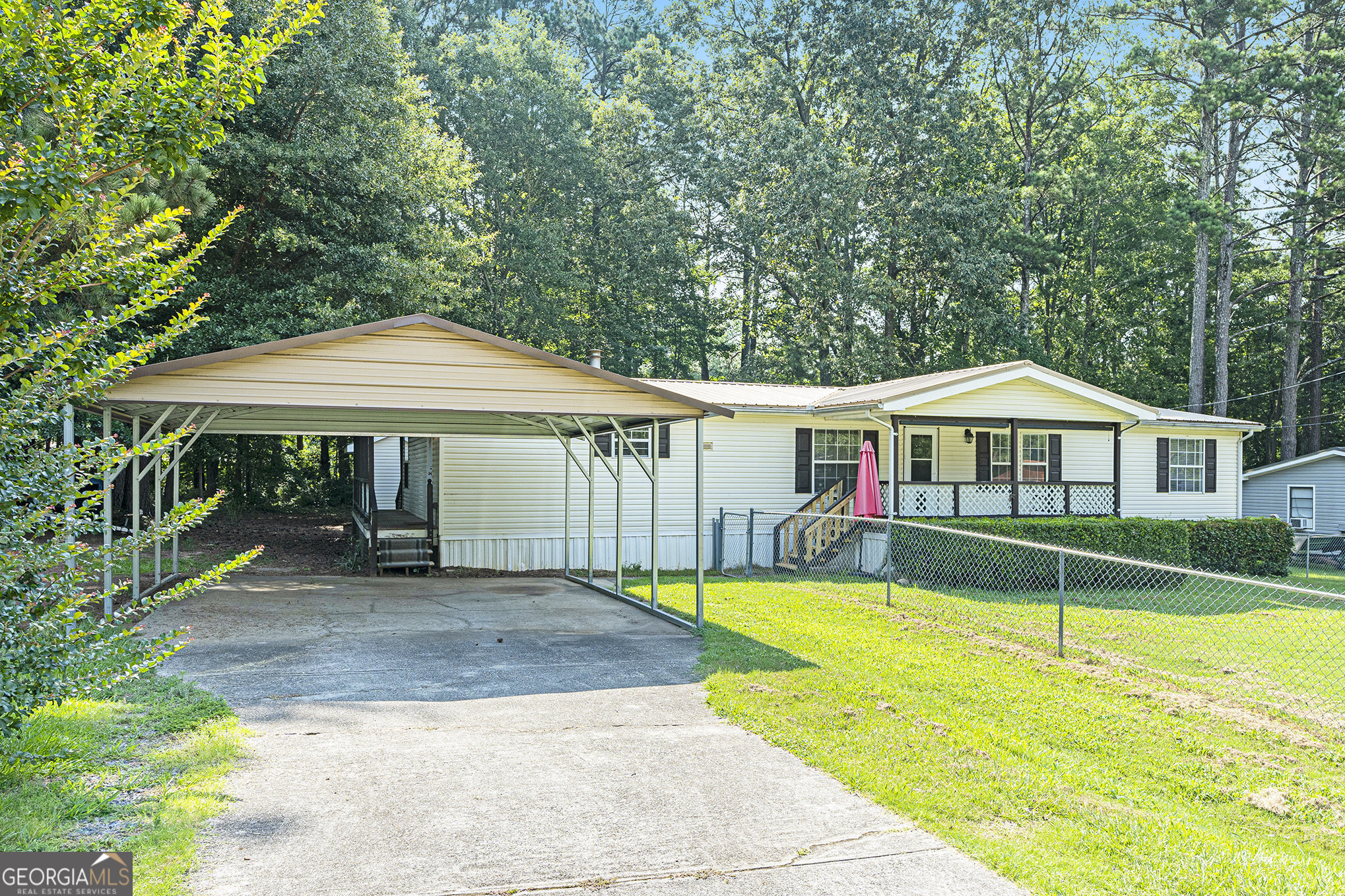 340 Loblolly Ridge Locust Grove, GA 30248 - Photo 4 of 26 a view of a house with a yard table and chairs under an umbrella