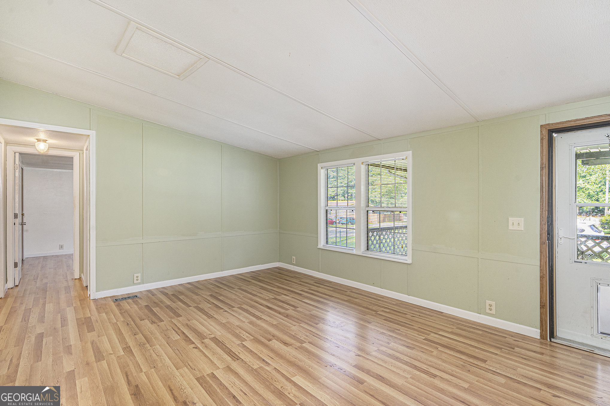 340 Loblolly Ridge Locust Grove, GA 30248 - Photo 6 of 26 a view of an empty room with wooden floor and a window