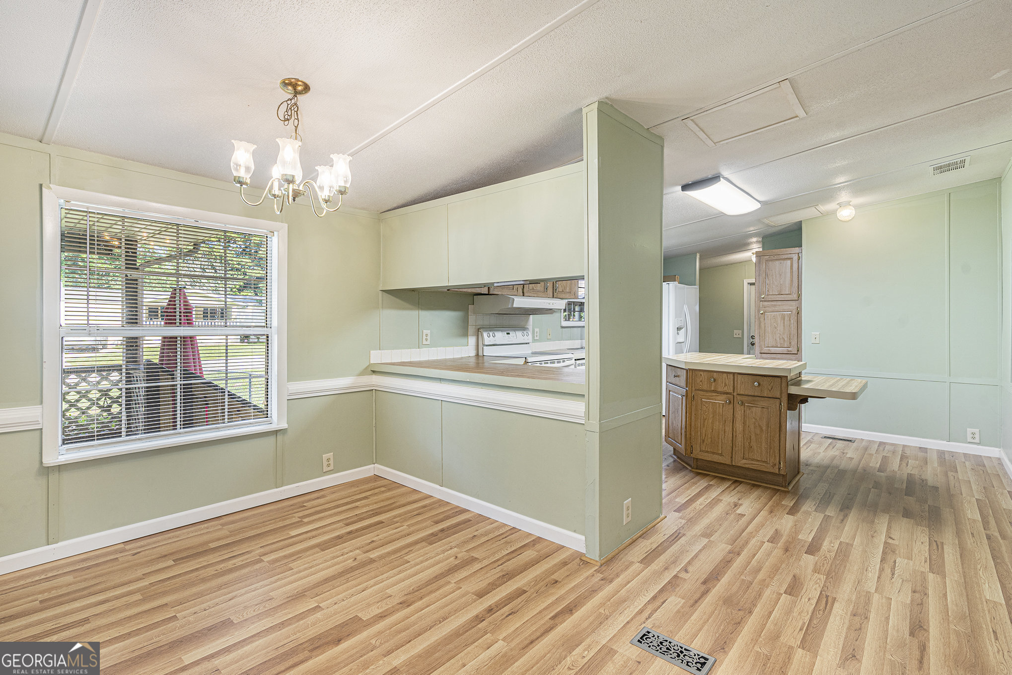340 Loblolly Ridge Locust Grove, GA 30248 - Photo 7 of 26 a open kitchen with kitchen island wooden floors center island and stainless steel appliances