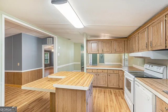 a kitchen with a sink and wooden floor