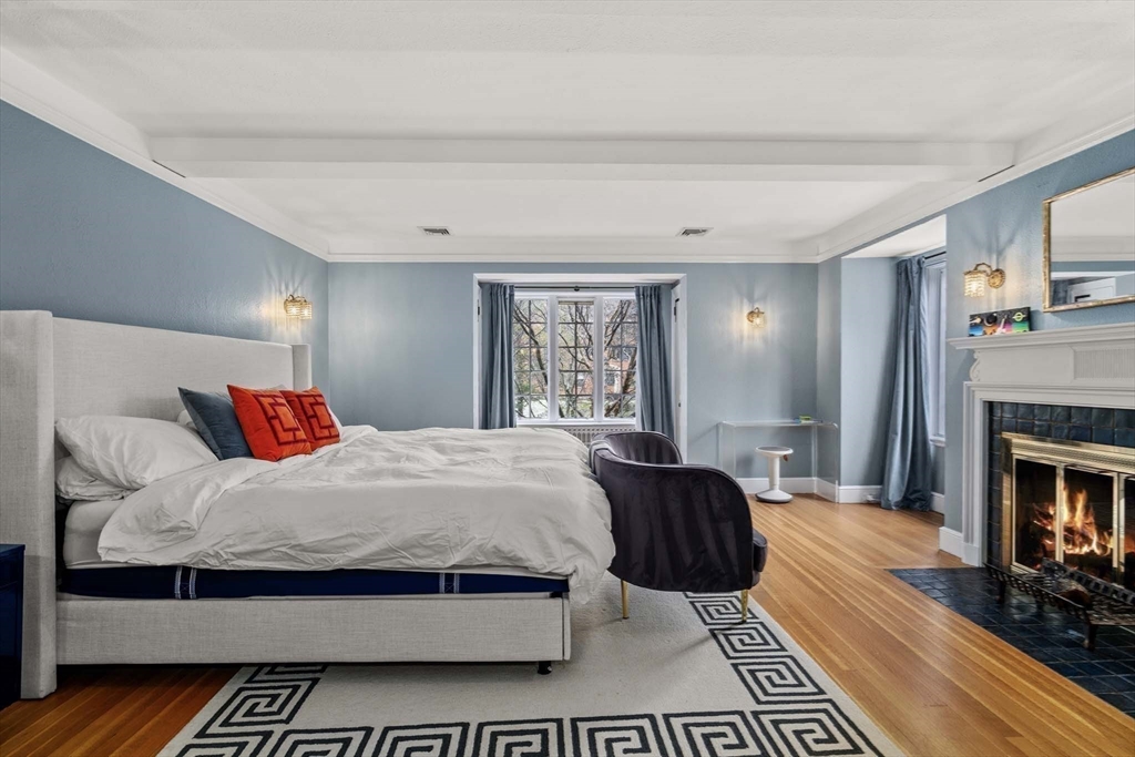 27 Tudor Road Newton, MA 02467 - Photo 21 of 42 a bedroom with a large bed and a fireplace
