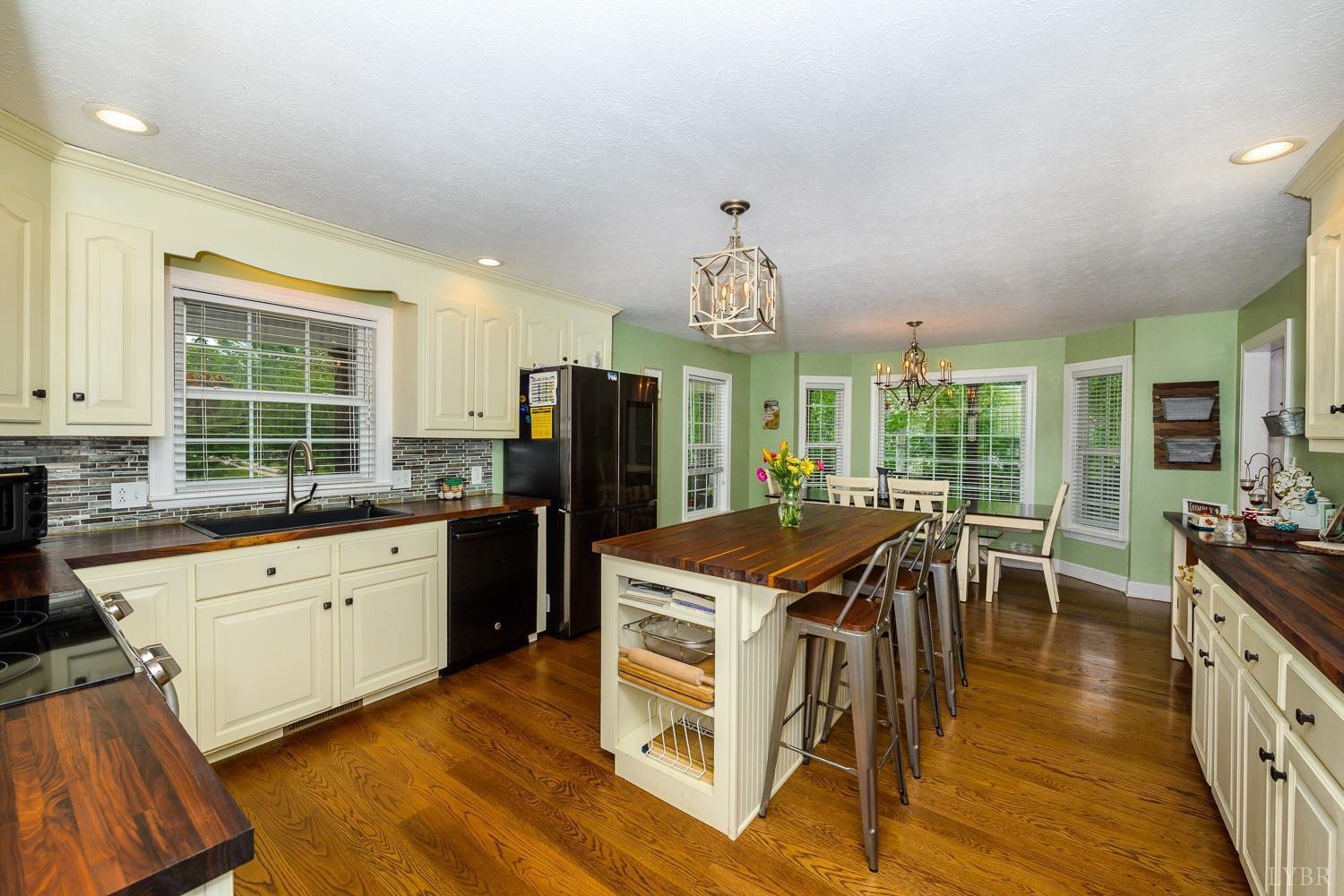 149 Locust Street Amherst, VA 24521 - Photo 19 of 86 a kitchen with stainless steel appliances granite countertop a stove a refrigerator a kitchen island a stove and a wooden floors