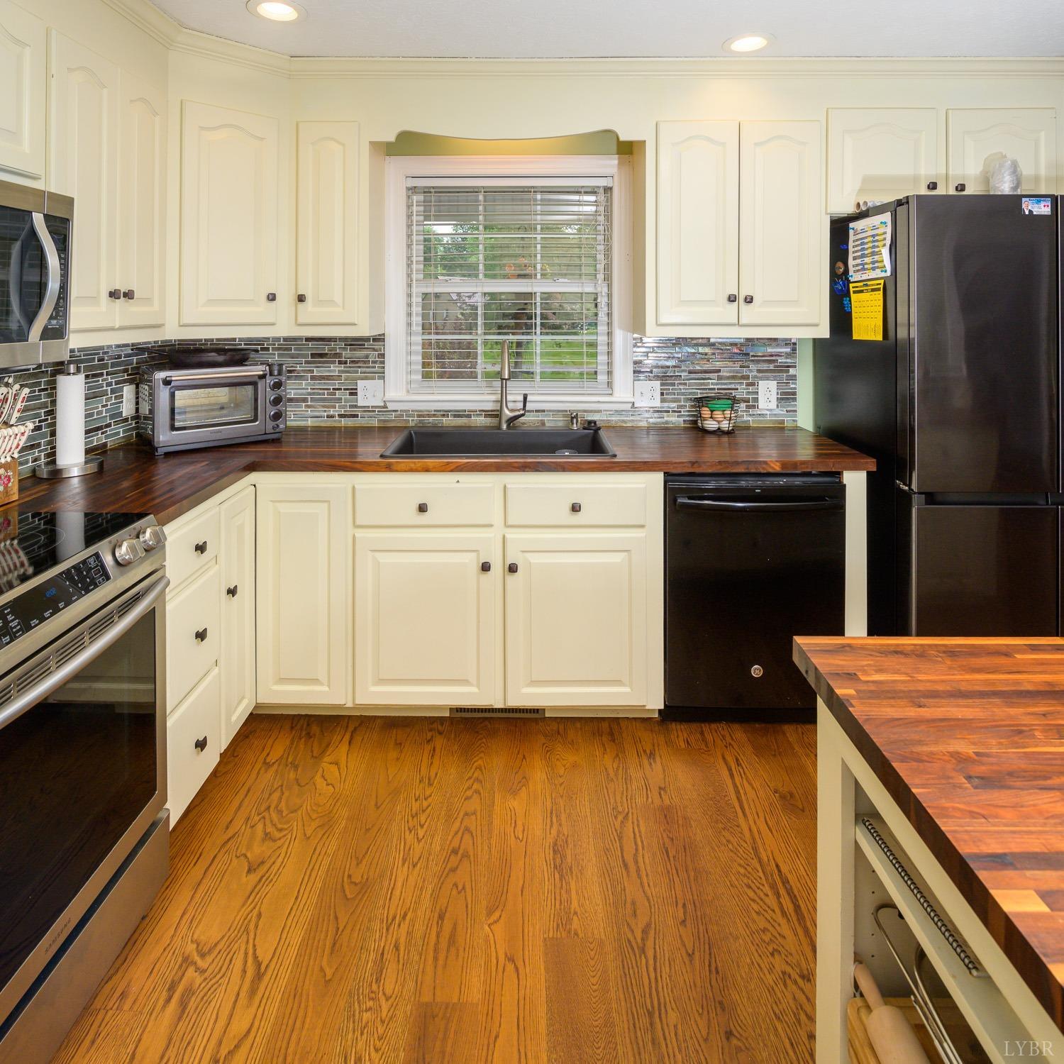 149 Locust Street Amherst, VA 24521 - Photo 21 of 86 a kitchen with granite countertop a stove a sink dishwasher a refrigerator and cabinets with wooden floor