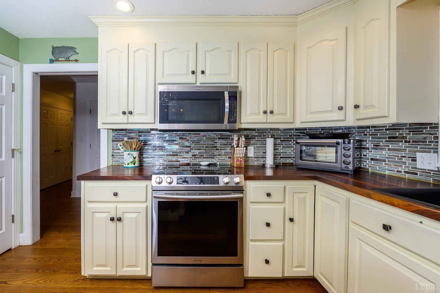 149 Locust Street Amherst, VA 24521 - Photo 23 of 86 a kitchen with stainless steel appliances granite countertop a stove a sink and white cabinets