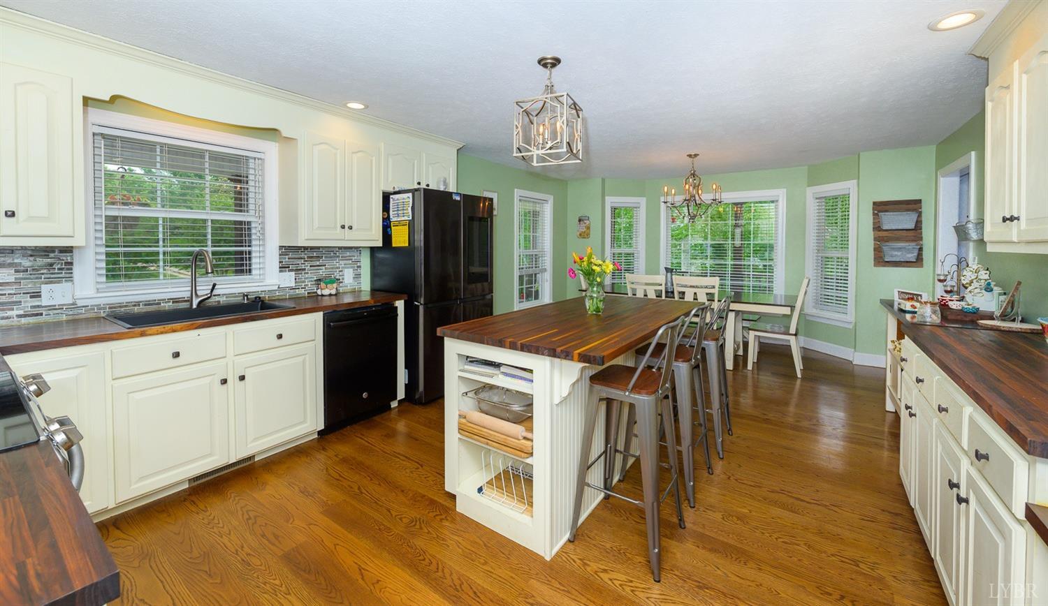 149 Locust Street Amherst, VA 24521 - Photo 24 of 86 a kitchen with stainless steel appliances granite countertop a stove a refrigerator a kitchen island a dining table and chairs