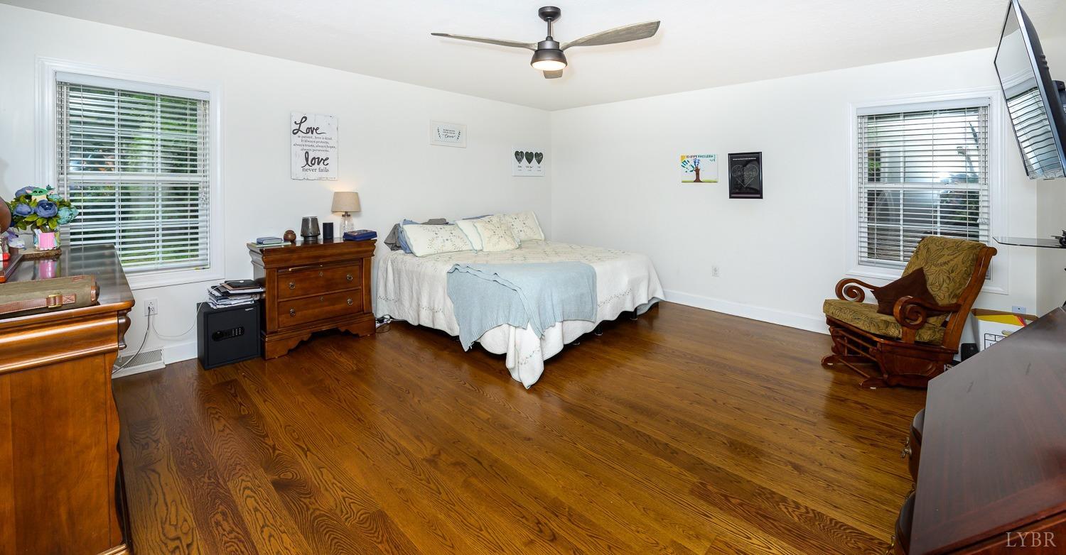 149 Locust Street Amherst, VA 24521 - Photo 29 of 86 a spacious bedroom with a bed and wooden floor