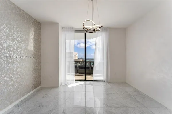a view of a room with a chandelier fan and a window