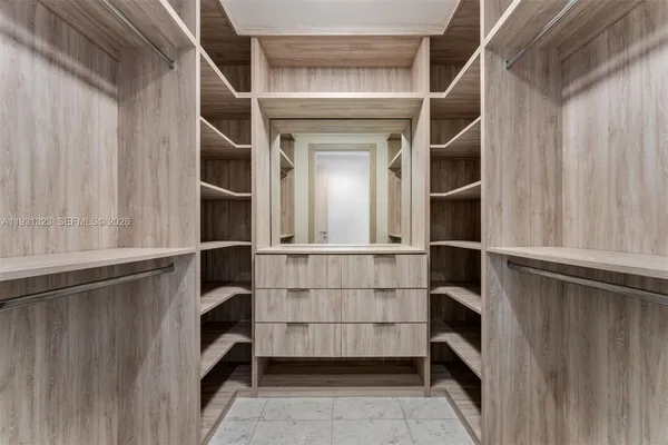 a view of walk in closet with empty racks