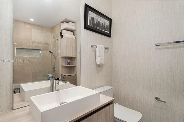 a bathroom with a sink a toilet and shower